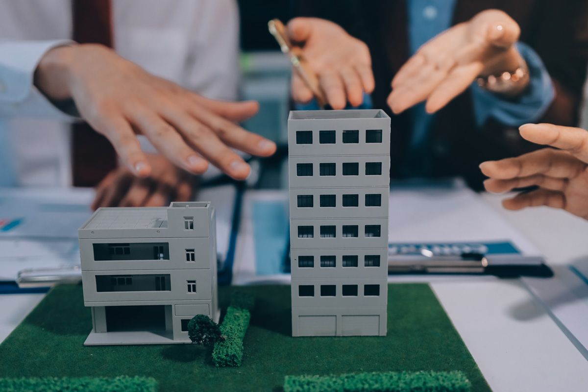 real estate investment team discussing applicable tax laws for property acquisition